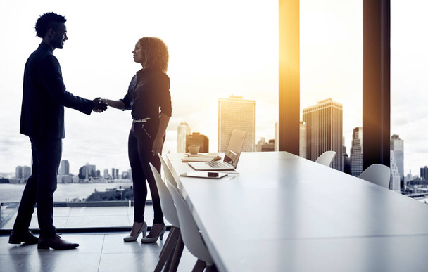 Partnering together to enhance the future of business. Shot of two businesspeople shaking hands in an office. - Photo, image