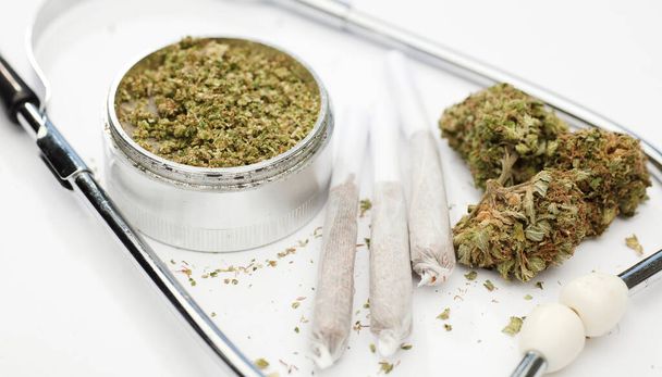 marijuana buds, joint, phonendoscope, with white background. - Фото, изображение