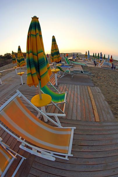 slunce vychází na pláži stále opuštěné, s deštníky a slunce se - Fotografie, Obrázek