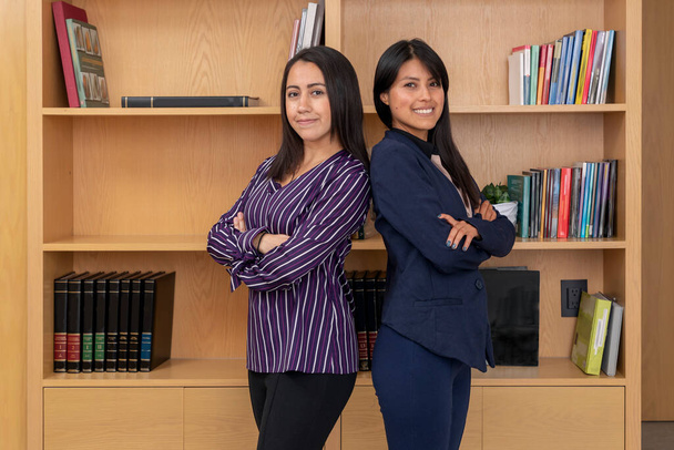 Portrait of two young businesswomen standing in front of lobby looking at camera. - Foto, afbeelding