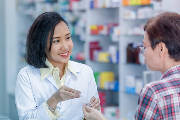 Farmacéutica asiática o médico explicando medicamento recetado a paciente mujer en una farmacia Tailandia  - Foto, imagen