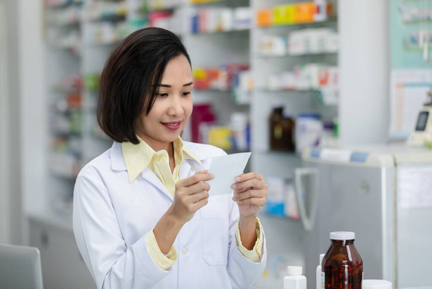 nuoret aasialaiset naiset apteekissa tarkistamassa lääkkeitä ja pakkauksia lääke reseptin mukaan apteekissa Thaimaassa - Valokuva, kuva