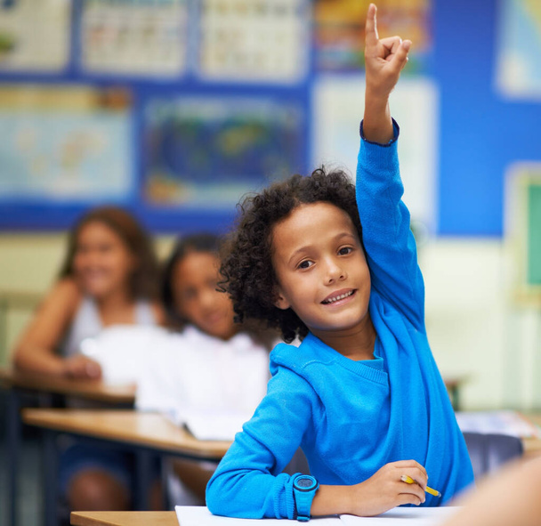 Escoge yo sé la respuesta. Un niño levantando la mano en clase. - Foto, Imagen