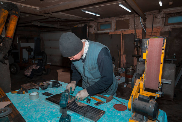 Un trabajador marca una tubería de perfil de acero inoxidable con un marcador usando un cuadrado - Foto, imagen