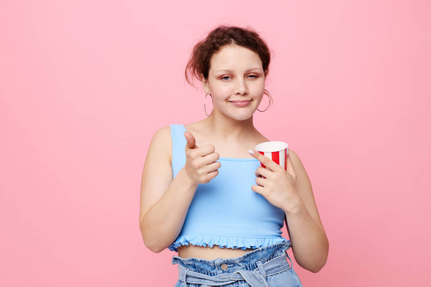 girl drinking a drink disposable glass pink background unaltered - Foto, Bild