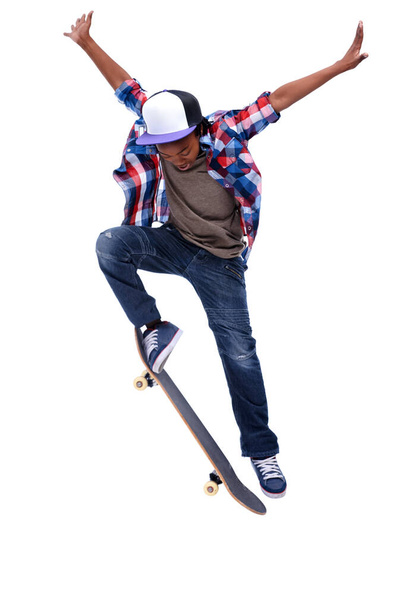 Nascido para embarcar. Um menino afro-americano fazendo um truque em seu skate. - Foto, Imagem