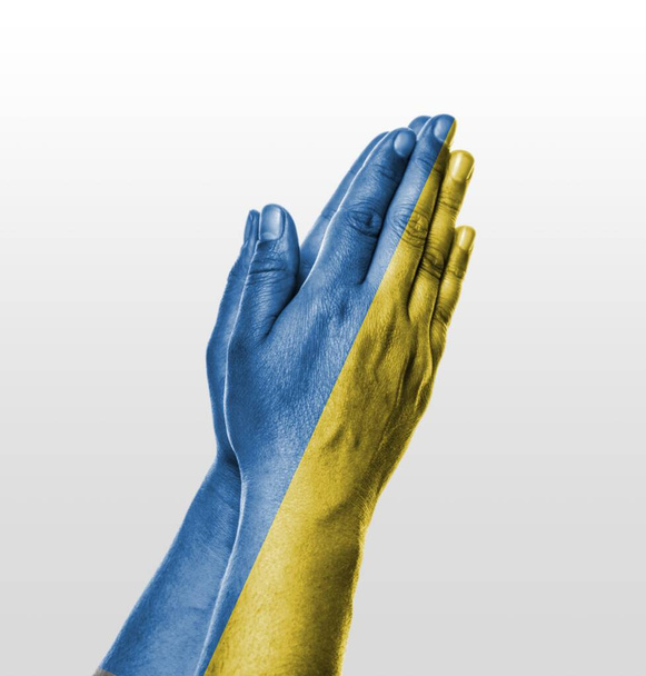 Προσευχήσου για την Ουκρανία. Τα χέρια προσεύχονται στην ουκρανική σημαία - Φωτογραφία, εικόνα