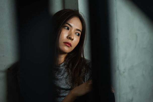 Young woman sitting sad with shadow foreground, depression emotion, looking space in dark room, Portrait of young beautiful woman or female or girl sitting expression depression emotional alone - Photo, Image