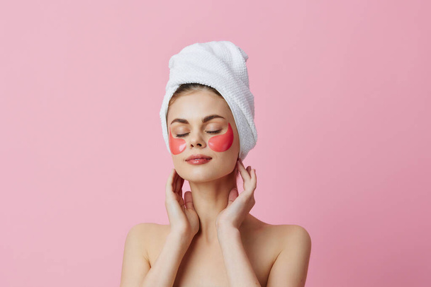 女性ピンクのパッチを頭の上にタオルで顔を閉じるライフスタイル - 写真・画像