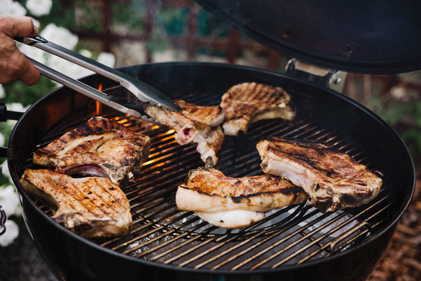 Primo piano di bistecche grigliate di carne su barbecue con fiamme aperte. BBQ in cortile - Foto, immagini