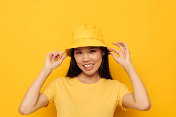 Sarı tişörtlü ve şapkalı bir kadın duygularını dışa vuruyor. - Fotoğraf, Görsel