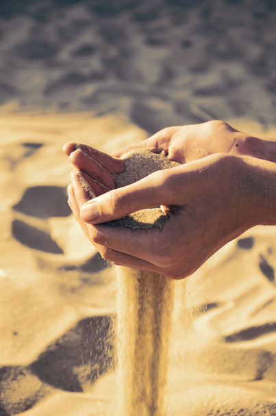 Тонированное изображение песок льется из женских рук
 - Фото, изображение