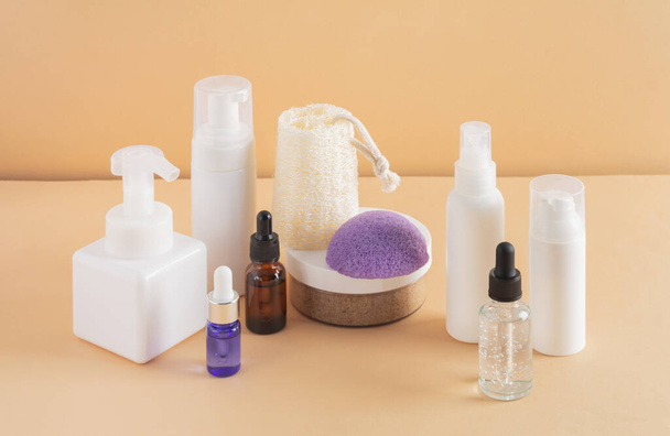 Facial cosmetic products and konjac sponge on a beige background - Fotó, kép