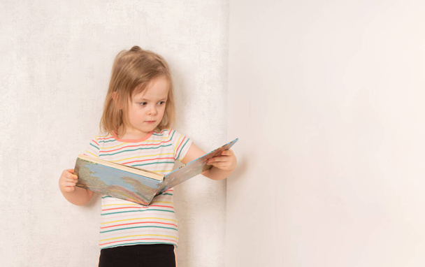 Serious child standing and studying a book - Photo, image