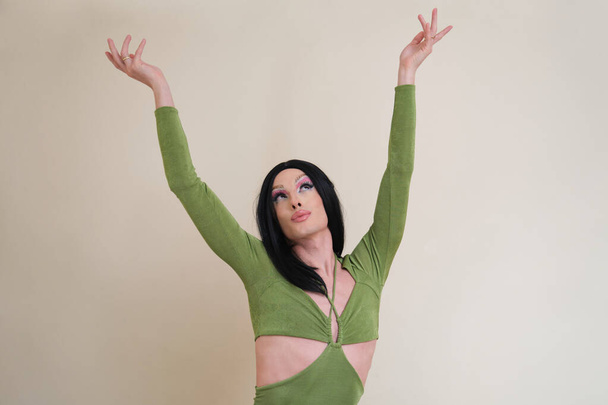 Porträt einer Drag-Queen-Person, die mit erhobenen Armen nach oben blickt. - Foto, Bild