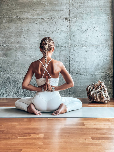 young woman sitting on floor and meditating in yoga pose - Φωτογραφία, εικόνα