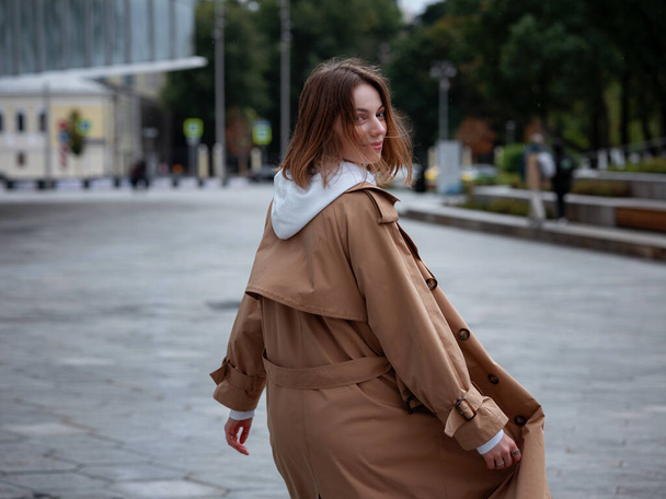 Piękna kobieta w pięknym beżowym płaszczu spacer jesienią pochmurny Moskwa, Zaryadye park. Styl uliczny. Podróż do Rosji. - Zdjęcie, obraz