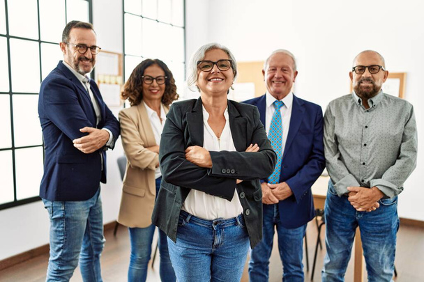 Group of middle age business workers smiling happy standing with arms crossed gesture at the office - Fotoğraf, Görsel