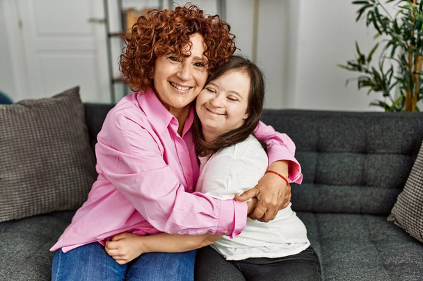 Mère mature et fille duvet syndrome à la maison étreignant avec amour - Photo, image