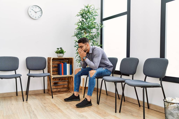Young arab man desperate sitting on chair at waiting room - Photo, Image