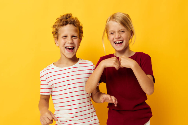 Cute preschool kids standing side by side posing childhood emotions yellow background - Fotoğraf, Görsel