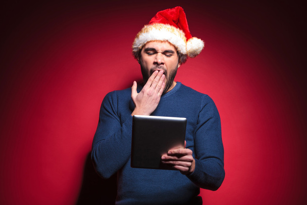 Babbo Natale stanco di leggere su un tablet pad computer
 - Foto, immagini