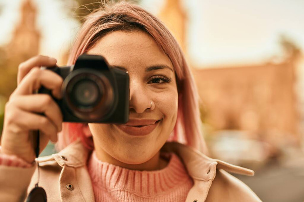 Şehre refleks kamera kullanarak gülümseyen genç İspanyol kız.. - Fotoğraf, Görsel