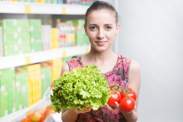 Woman smiling and holding vegetables - Foto, Imagem
