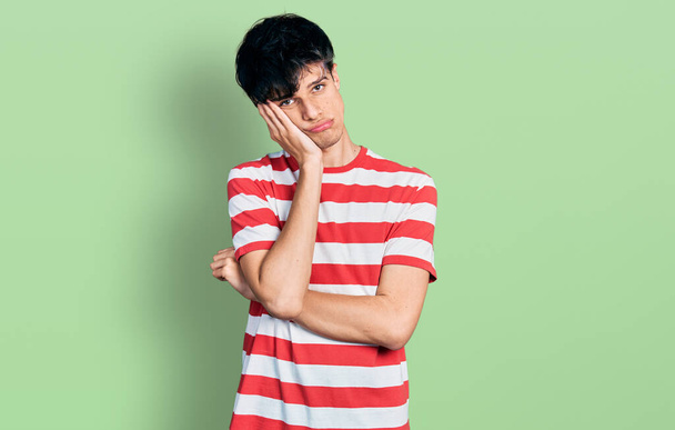 Handsome hipster young man wearing casual striped t shirt thinking looking tired and bored with depression problems with crossed arms.  - Photo, Image