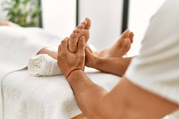 Fizyoterapi kliniğindeki genç beyaz kadın profesyonel terapist tarafından kas masajı yaptırıyor. Fizyoterapist müşteriye ayak masajı yapıyor. - Fotoğraf, Görsel