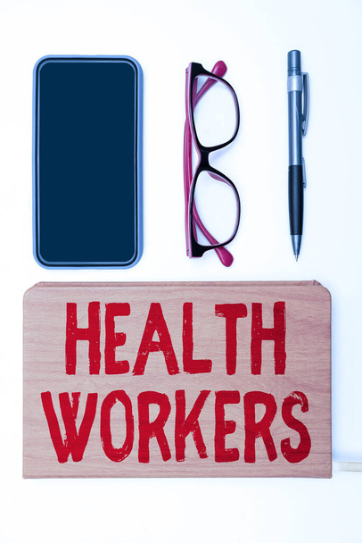 Psaní textu Zdravotničtí pracovníci. Koncept znamená ukázat, čí práce chránit zdraví svých komunit Kancelářské potřeby přes stůl s klávesnicí a brýlemi a kávový pohár pro práci - Fotografie, Obrázek