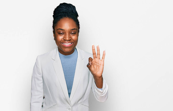 自信を持って幸せな笑顔ながら、若いアフリカ系アメリカ人の女性は、ビジネス服を着て指の数3で示すと指摘します.  - 写真・画像