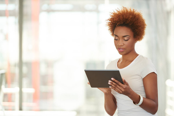 Explorando internet. Fotografía de una joven empresaria usando una tableta digital en la oficina. - Foto, Imagen