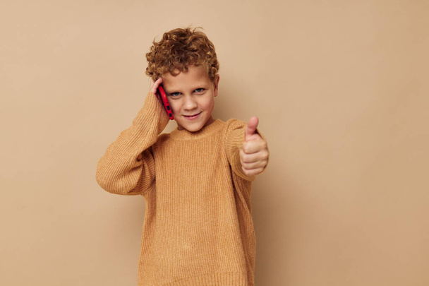 little boy with curly hair red phone technology fun - Φωτογραφία, εικόνα