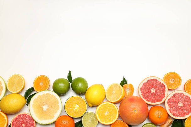 Different citrus fruits on white background, space for text - Foto, afbeelding