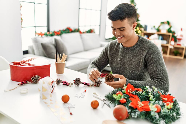 Genç İspanyol adam evde el yapımı Noel süsü yapıyor. - Fotoğraf, Görsel