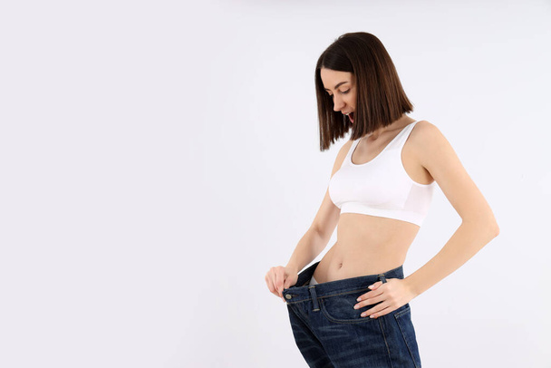 Concetto di perdita di peso con giovane donna magra su sfondo chiaro - Foto, immagini
