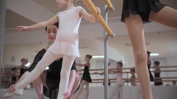 Εκπαίδευση μπαλέτου - μικρά κορίτσια που εκπαιδεύονται σε pointe παπούτσια με τη βοήθεια του εκπαιδευτή τους - Πλάνα, βίντεο