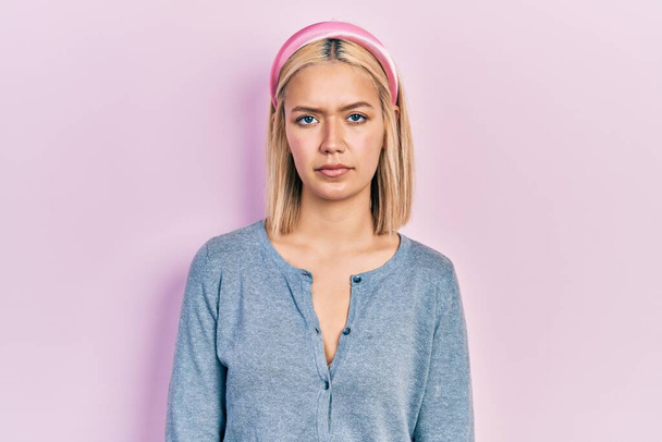 Beautiful blonde woman standing over pink background depressed and worry for distress, crying angry and afraid. sad expression.  - Valokuva, kuva