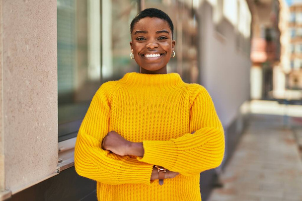 jonge afrikaanse amerikaanse vrouw glimlachen gelukkig staan in de stad. - Foto, afbeelding