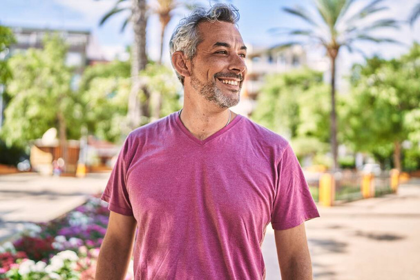 Középkorú spanyol férfi mosolyogva magabiztos a parkban - Fotó, kép