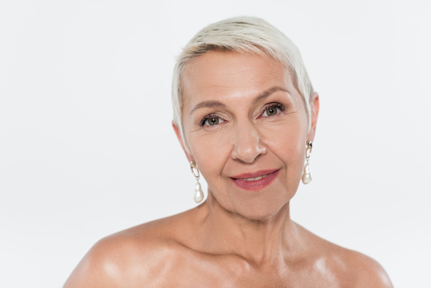 Elderly woman with naked shoulders looking at camera isolated on grey  - Photo, Image