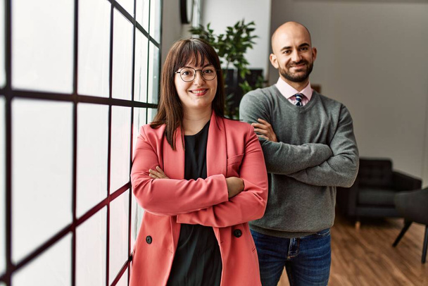 Two hispanic business workers smiling happy with arms crossed gesture standing at the office. - 写真・画像