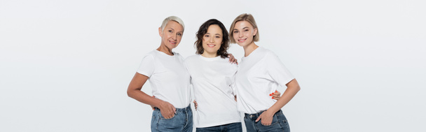 Young woman hugging friends in white t-shirts isolated on grey, banner  - Zdjęcie, obraz