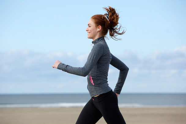 Bela jovem mulher exercitando-se na praia
 - Foto, Imagem