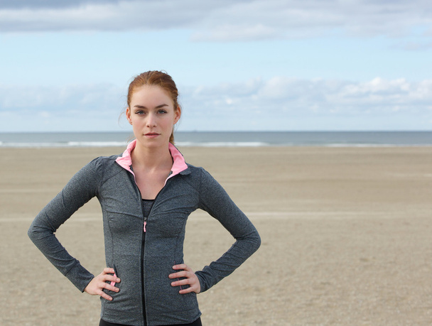 Itsevarma urheilu nainen seisoo rannalla
 - Valokuva, kuva