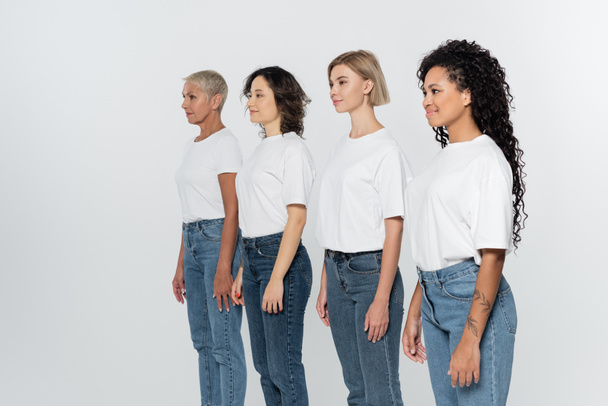 Interracial women in white t-shirts looking away isolated on grey, feminism concept - Foto, immagini