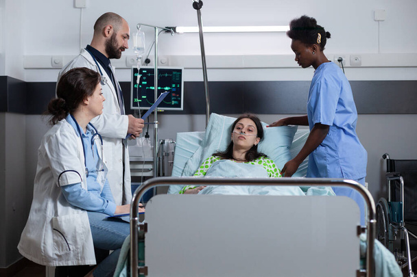Vrouw met ziekte verbonden met infuuslijn en monitor die vitale functies toont die medische zorg ontvangen - Foto, afbeelding