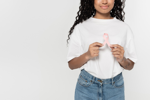 Vista cortada da jovem afro-americana segurando fita rosa da consciência do câncer de mama isolada no cinza  - Foto, Imagem