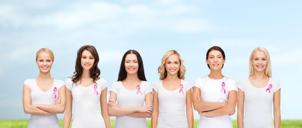 smiling women with pink cancer awareness ribbons - Foto, imagen